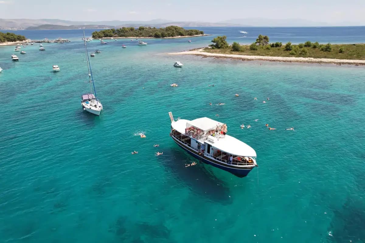 Traditional Dalmatian wooden gajeta boat cruising the crystal-clear turquoise waters of the Adriatic Sea near Split, Croatia