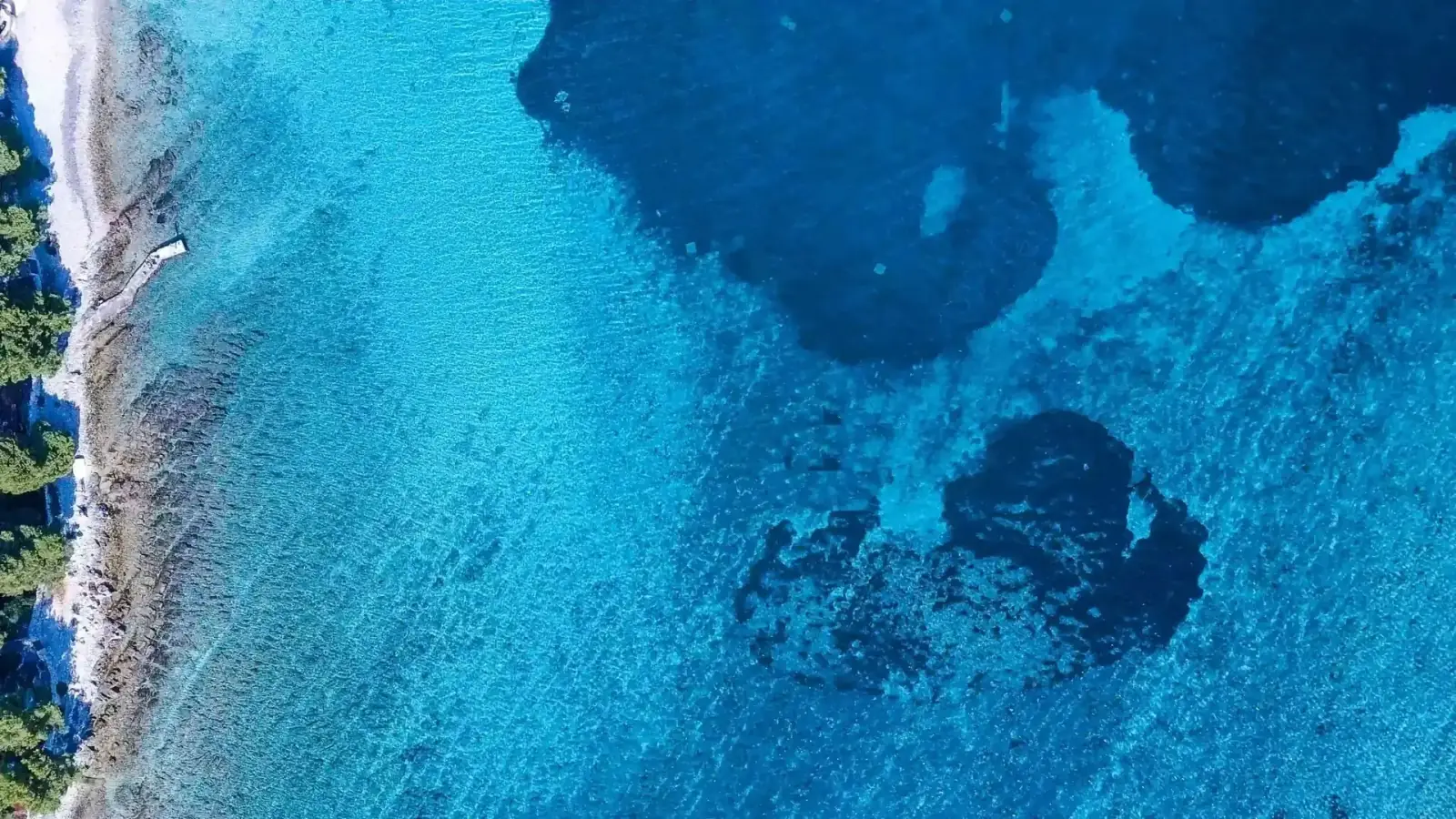 The turquoise water of the Blue Lagoon at Krknjaši near Šolta, Croatia, viewed from the deck of a traditional wooden boat